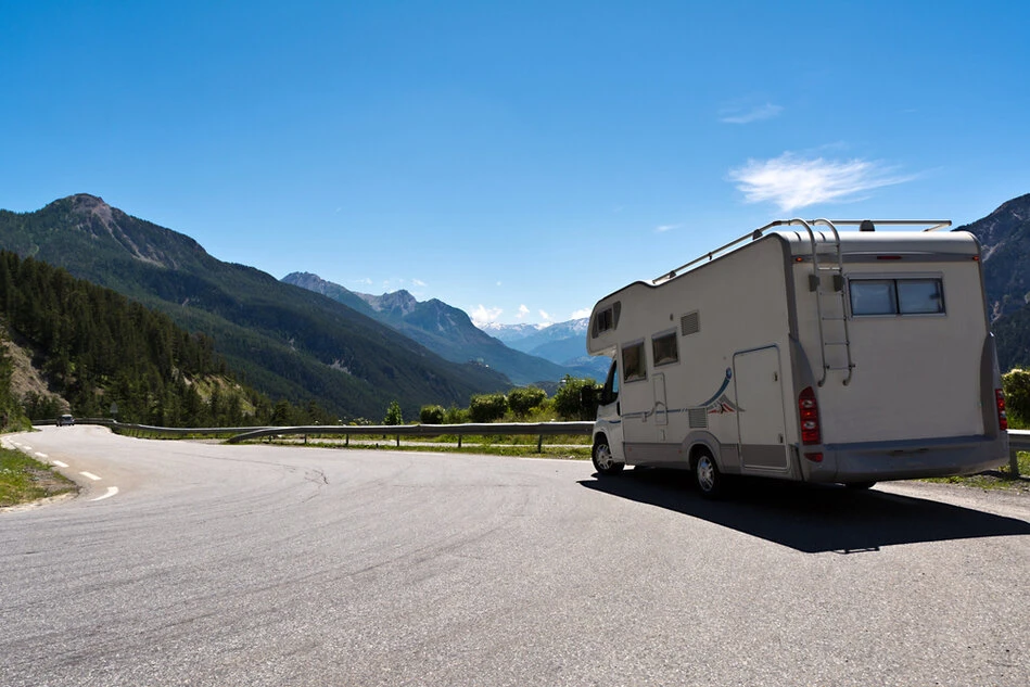 Wohnmobil fährt eine Küstenstraße entlang